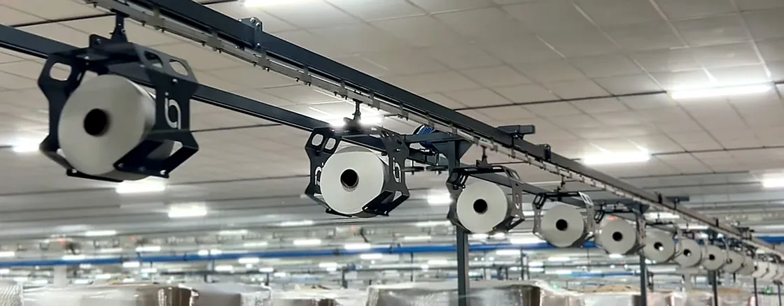 Cone Transport System carrying yarn packages on an overhead track in a spinning mill